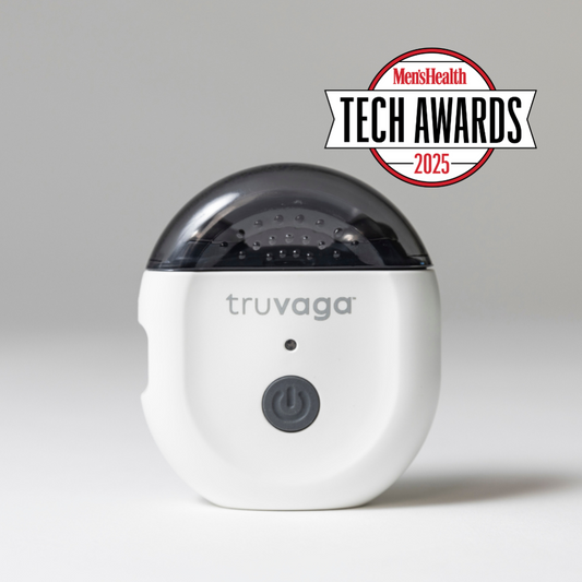 A white Truvaga Vagus Nerve Stimulator with a power button, marked "truvaga," features a dark translucent top and the "Men’s Health Tech Awards 2025" logo, designed to enhance mental clarity and relieve stress.