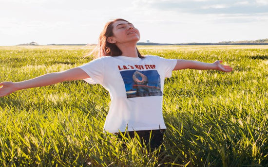 A woman in a field with her arms outstretched experiencing the benefits of OHP Health supplements from Boulder Longevity Institute.