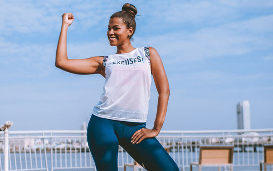 A young woman showcasing her muscular strength and health on a dock.